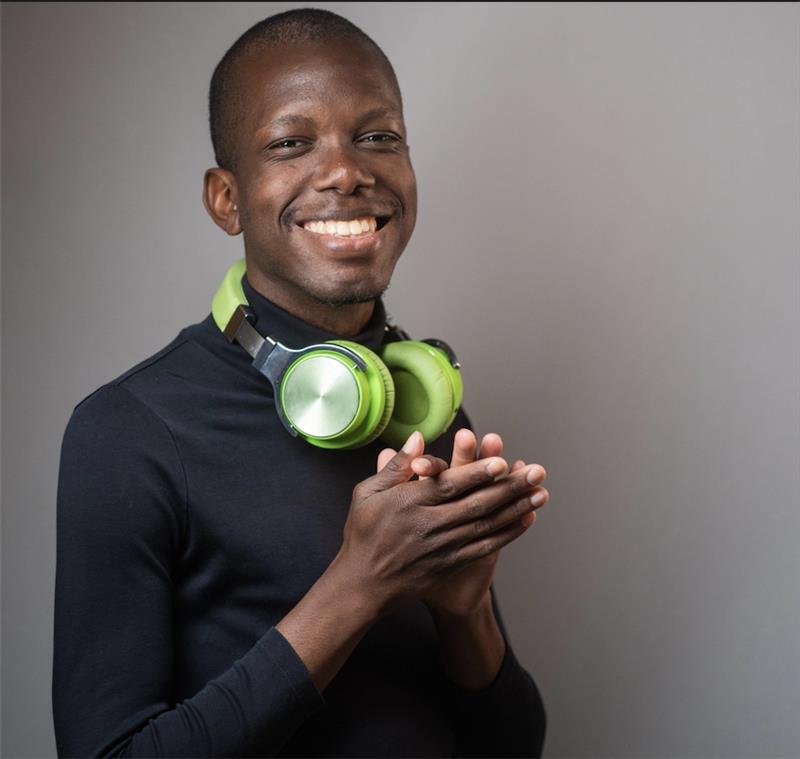 A Ph.D. student posing for a photo in front of a blank wall