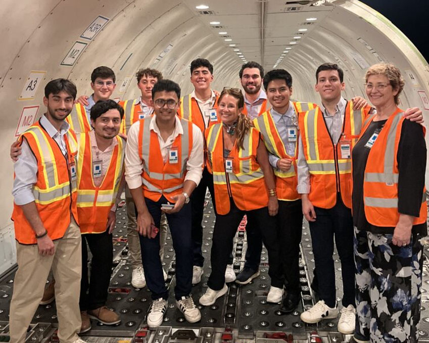 A group of students wearing orange safety vests
